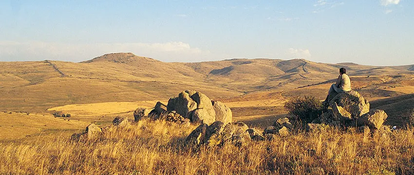 main background, a man looking over a valley